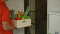 CLOSE UP: Unrecognizable courier rings doorbell as he delivers a box of produce.