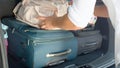 CLOSE UP: Unrecognizable male tourist packing his and his girlfriend`s bags in the back of a spacious black car. Royalty Free Stock Photo