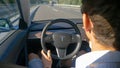 CLOSE UP: Unrecognizable man touches the touchscreen in a Tesla while driving