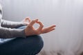 Close-up of unrecognizable peaceful young woman sitting in lotus pose and meditation, practicing yoga at home, hands fingers, calm Royalty Free Stock Photo