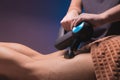 Close-up of unrecognizable professional male masseur massaging leg calf muscles using massage gun percussion tool of Royalty Free Stock Photo