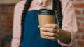 Close-up unrecognizable woman barista waitress in apron holding disposable paper cup with hot coffee or tea female small Royalty Free Stock Photo