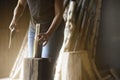 Close-up of an unrecognizable woman holding a piece of wood to split it into smaller pieces to make firewood. logs in the