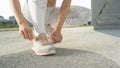 CLOSE UP: Unrecognizable young fit woman is tying up her sneaker shoelaces. Royalty Free Stock Photo