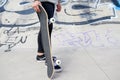 Close up of unrecognizable young man holding longboard or skateboard in the park. Royalty Free Stock Photo