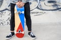 Close up of unrecognizable young man holding longboard or skateboard in the park. Royalty Free Stock Photo