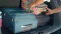 CLOSE UP: Unrecognizable young traveler packing baggage in the spacious boot. Royalty Free Stock Photo