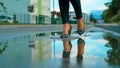 CLOSE UP: Unrecognizable young woman wearing heels walks into a glassy puddle.