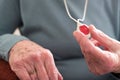 Close Up Of Unwell Senior Woman Holding Personal Alarm Button At