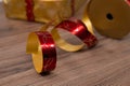 Close-up of a unwinded Christmas gift wrapping tape with gift box in bakcground on a wooden table