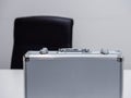 Close up of an upright metal briefcase on a table in an office setting. Business deal / cash transaction concept Royalty Free Stock Photo