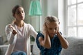 Close up upset little girl covering ears, ignoring angry yelling mother Royalty Free Stock Photo