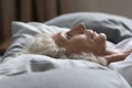 Close up upset sleepless middle aged woman lying in bed Royalty Free Stock Photo