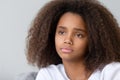 Close up upset thoughtful African American teenage girl sitting alone Royalty Free Stock Photo