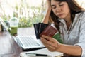 Close up of upset young Asian woman close her eyes while holding credit card with feeling stressed and broke. financial problem, Royalty Free Stock Photo