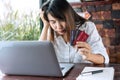 Close up of upset young Asian woman close her eyes while holding credit card with feeling stressed and broke. financial problem Royalty Free Stock Photo