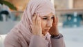 Close-up upset young woman gets bad news feels stressful anxiety frustrated muslim girl suffers from headache grabs head