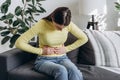 Close up of upset young woman suffering from menstrual pain. Girl with hands squeezing belly having painful stomach ache or period Royalty Free Stock Photo