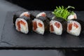 Close-up of uramaki sushi rolls with red caviar salmon tuna cucumber and avocado isolated on black background. Delicious Royalty Free Stock Photo