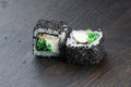 Close-up of uramaki sushi rolls with red caviar salmon tuna cucumber and avocado isolated on black background. Delicious Royalty Free Stock Photo