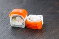 Close-up of uramaki sushi rolls with red caviar salmon tuna cucumber and avocado isolated on black background. Delicious Royalty Free Stock Photo