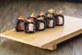 Close-up of uramaki sushi rolls with red caviar salmon tuna cucumber and avocado isolated on black background. Delicious Royalty Free Stock Photo