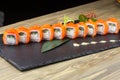 Close-up of uramaki sushi rolls with red caviar salmon tuna cucumber and avocado isolated on black background. Delicious Royalty Free Stock Photo