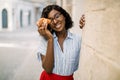 Close up urban lifestyle portrait of pretty cute African American lady, smiling to camera, funny hiding her eye with Royalty Free Stock Photo