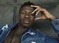 Young handsome and attractive athletic black African American man in open denim shirt showing tattoo muscular torso posing in cool Royalty Free Stock Photo