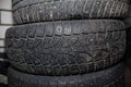 Close-up of used auto wheels folded horizontally. Discarded winter spiked car tires, worn out tread