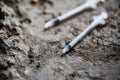Close up of used drug syringes on ground Royalty Free Stock Photo