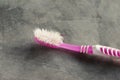 Close up Used pink toothbrush with cement background.