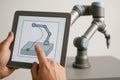 Engineer programming a collaborative robot arm with a tablet interface Royalty Free Stock Photo