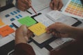 Close up ux developer and ui designer brainstorming about mobile app interface wireframe design on table with customer breif and Royalty Free Stock Photo