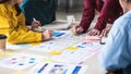 Close up ux developer and ui designer brainstorming about mobile app interface wireframe design on table with customer brief and