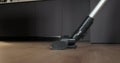Close-up of vacuum cleaner with a turbo brush a laminate floor. House cleaning, housework concept.