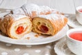 Close up. Valentine`s day. French croissants and berry tea in vintage porcelain cups.One of the croissants is cut in half, inside Royalty Free Stock Photo