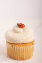 Close up of a vanilla cupcake with buttercream frosting and flower Royalty Free Stock Photo