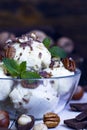 Close up Vanillaice cream with mint, nuts and chocolate on dark background. Ice cream decoration. Vegetarian food. Summer, sweet