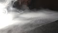 Close up of vaper exhaling club of milk steam from an electronic cigarette or hookah on the surface of floor. Male mouth