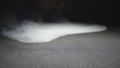 Close up of vaper exhaling club of milk steam from an electronic cigarette or hookah on the surface of floor. Male mouth