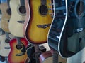 Close-up of a variety of acoustic wooden guitars in a musical instrument store, background or concept about music Royalty Free Stock Photo