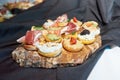 Close-up of a variety of Italian cicchetti appetizer on a wooden plate