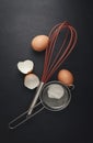 Close up of various baking utensils for baking cookies and cakes like rolling pin whisk and baking pan on dark background Royalty Free Stock Photo