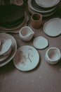 A close-up of various clay tableware with design. A pottery studio concept