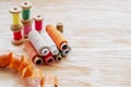 Close-up of various colored spools of sewing thread lie on a wooden table