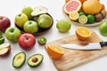 Close up of various colorful fresh summer fruits, Sliced fruits and a knife on cutting board isolated over white Royalty Free Stock Photo