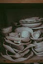 A close-up of various drying clay tableware on a shelf