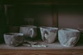 A close-up of various drying mugs and cups on a shelf