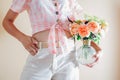 CLose up of vase with bouquet of fresh flowers in female hands. Fresh floral arrangement with orange white roses Royalty Free Stock Photo